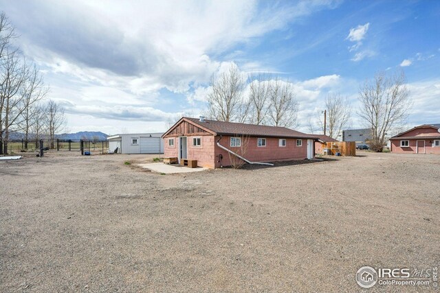 back of house with an outbuilding and fence