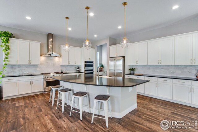 16335 Spanish Peak Way, Broomfield, CO 80023 - kitchen featuring wall chimney range hood, dark countertops, high quality appliances, and tasteful backsplash