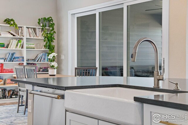 16335 Spanish Peak Way, Broomfield, CO 80023 - interior space featuring white cabinets, dark countertops, stainless steel dishwasher, and a sink