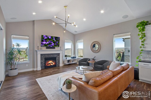 16335 Spanish Peak Way, Broomfield, CO 80023 - living area featuring high vaulted ceiling, a glass covered fireplace, a chandelier, dark wood finished floors, and recessed lighting