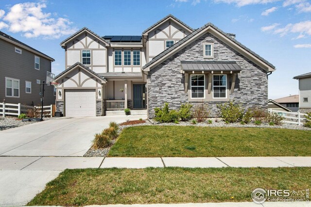 16335 Spanish Peak Way, Broomfield, CO 80023 - view of front of property with stone siding, fence, roof mounted solar panels, a front yard, and stucco siding