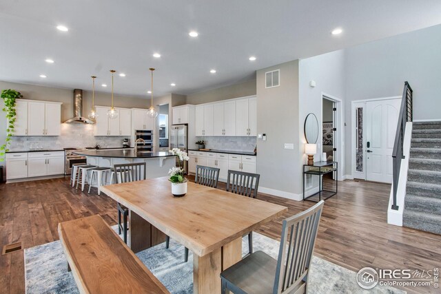 16335 Spanish Peak Way, Broomfield, CO 80023 - dining space featuring baseboards, visible vents, recessed lighting, stairway, and dark wood-type flooring