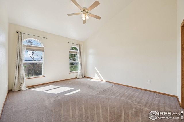 carpeted empty room with ceiling fan, high vaulted ceiling, and baseboards