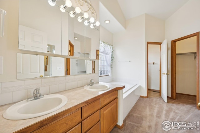 full bath featuring double vanity, a garden tub, a sink, and decorative backsplash