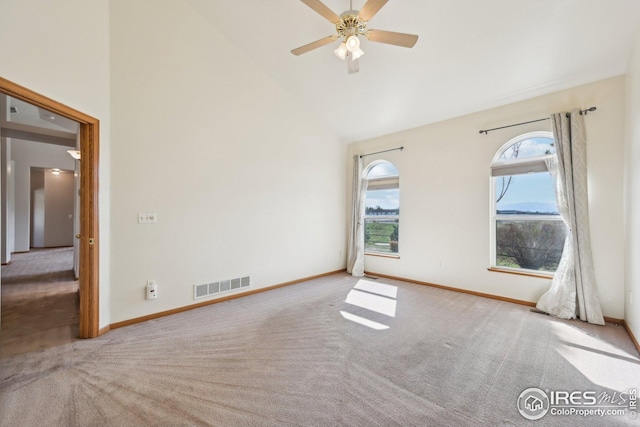spare room featuring visible vents, baseboards, ceiling fan, carpet, and high vaulted ceiling
