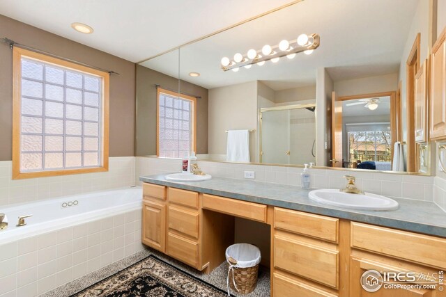 full bath featuring a shower stall, double vanity, a bath, and a sink