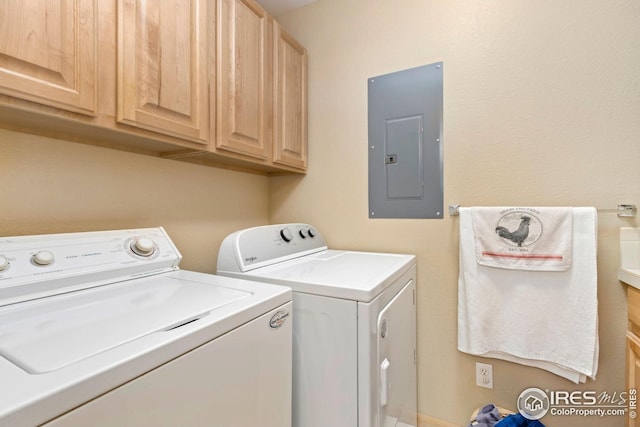 laundry room with electric panel, washer and clothes dryer, and cabinet space