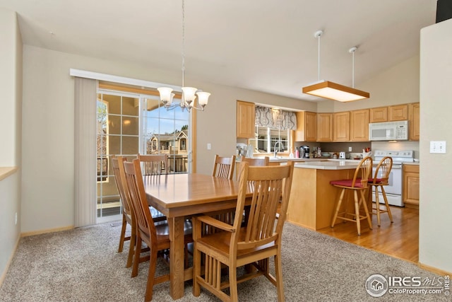 dining space with light colored carpet and an inviting chandelier