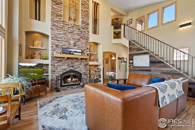 9 Mummy View Ct, Livermore, CO 80536 - living room featuring built in features, a towering ceiling, wood finished floors, and plenty of natural light