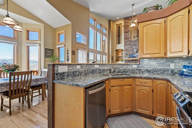 9 Mummy View Ct, Livermore, CO 80536 - kitchen with appliances with stainless steel finishes, a sink, a peninsula, light wood-style floors, and a towering ceiling