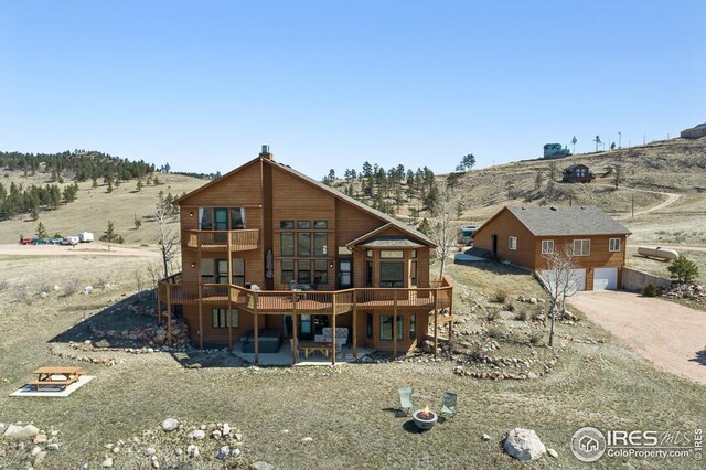 9 Mummy View Ct, Livermore, CO 80536 - rear view of property featuring a deck with mountain view, a garage, and dirt driveway