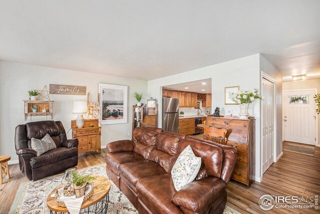 1226 Atwood St, Longmont, CO 80501 - living area with a fireplace, wood finished floors, stairway, and recessed lighting