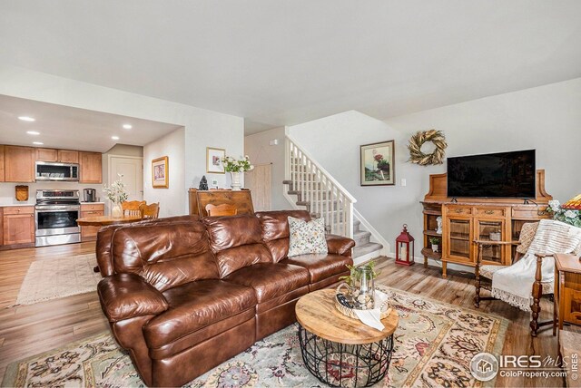 1226 Atwood St, Longmont, CO 80501 - living room featuring baseboards, a healthy amount of sunlight, wood finished floors, and a fireplace