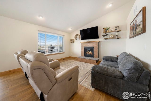 living area featuring vaulted ceiling, wood finished floors, a fireplace, visible vents, and recessed lighting