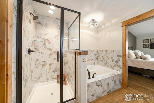 ensuite bathroom featuring a shower stall, a bath, connected bathroom, and wood finished floors