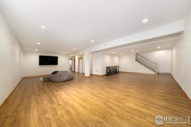 basement featuring stairs, baseboards, recessed lighting, and light wood-style floors