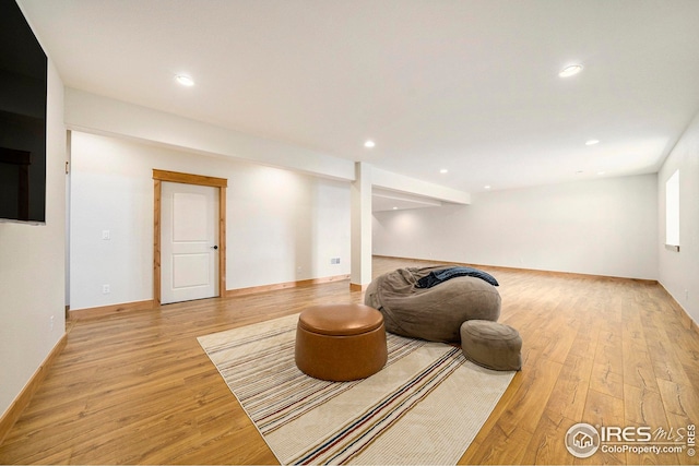 living area with light wood-style flooring and recessed lighting