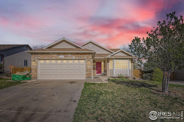 ranch-style house featuring an attached garage, driveway, stone siding, and a lawn