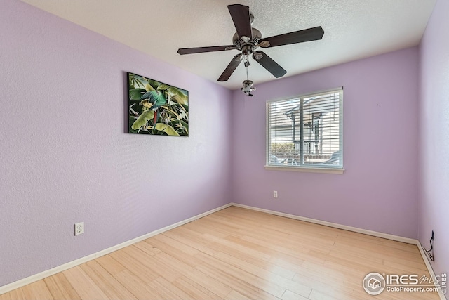 unfurnished room with baseboards, a ceiling fan, and wood finished floors