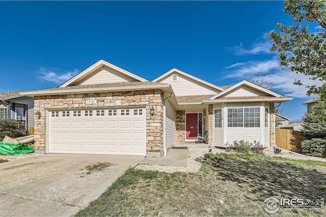 ranch-style home with concrete driveway, an attached garage, fence, and stone siding
