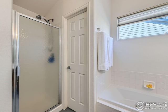 bathroom with a shower stall and a garden tub