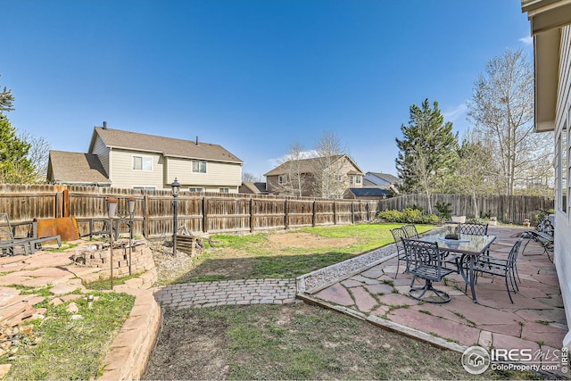 view of yard featuring a residential view, a patio area, and a fenced backyard