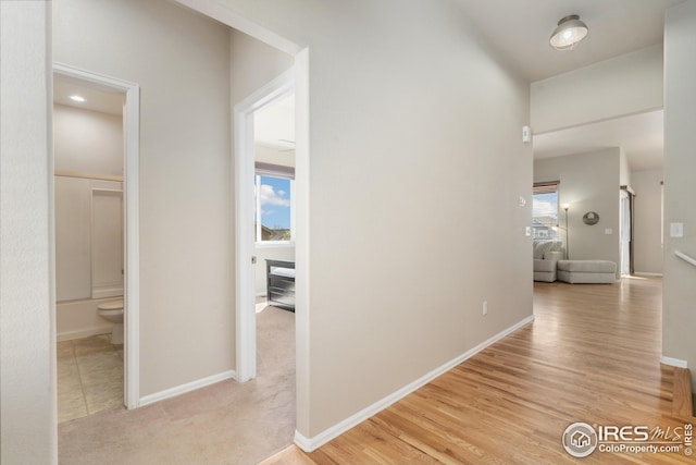 hallway featuring light wood-style floors and baseboards