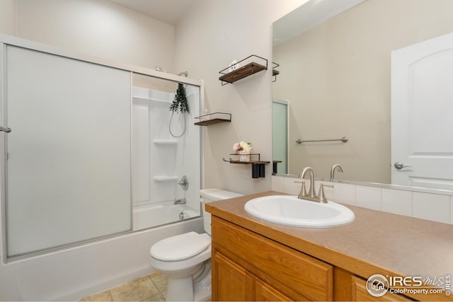 bathroom featuring tile patterned floors, vanity, shower / bath combination with glass door, and toilet