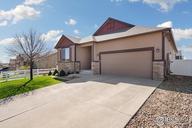 view of front of house featuring fence, stone siding, and board and batten siding
