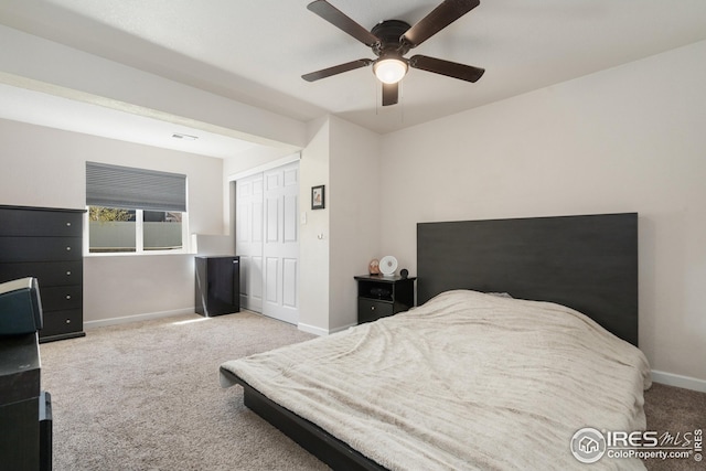 carpeted bedroom featuring a closet, baseboards, and ceiling fan