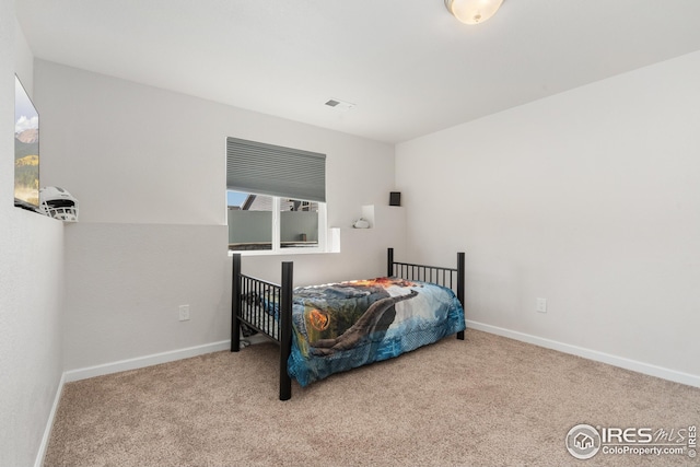 bedroom with carpet floors, visible vents, and baseboards