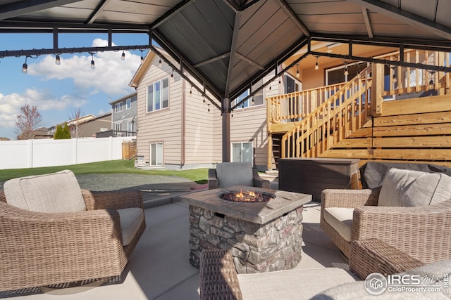 view of patio with stairway, fence, an outdoor fire pit, and a gazebo