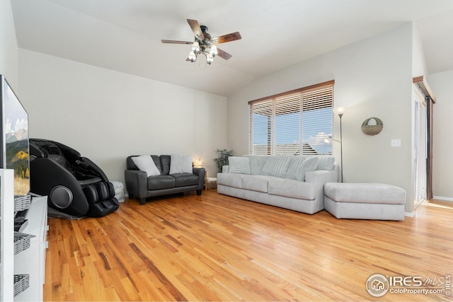 living area featuring lofted ceiling, a ceiling fan, baseboards, and light wood-style floors