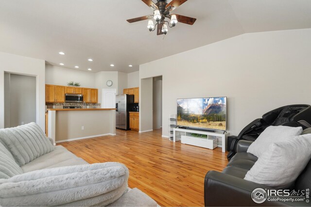 living room featuring light wood finished floors, a ceiling fan, recessed lighting, and lofted ceiling