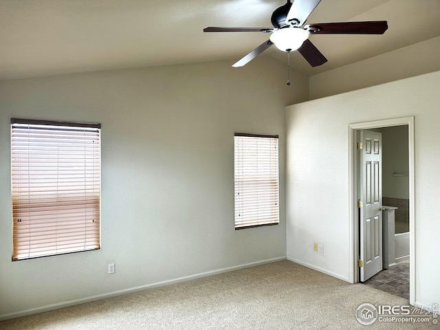 unfurnished bedroom with high vaulted ceiling, connected bathroom, ceiling fan, light colored carpet, and baseboards