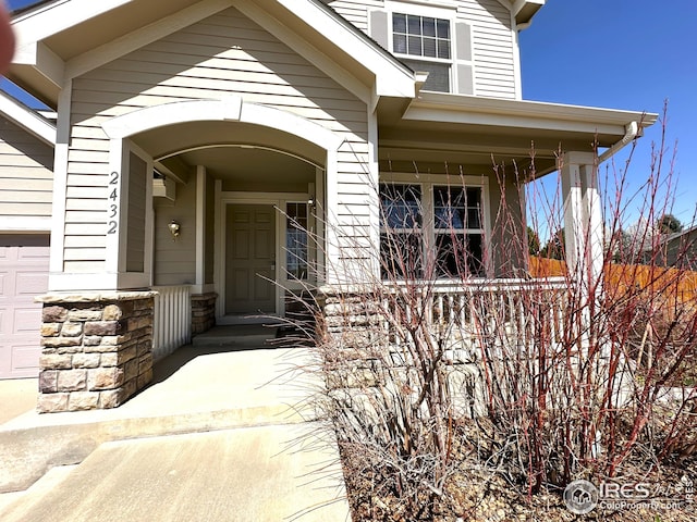 property entrance with stone siding and covered porch