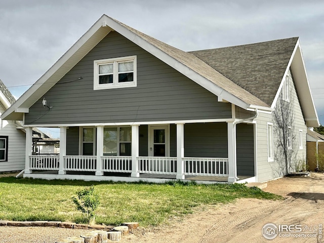 506 E 1st Ave, Otis, CO 80743 - view of front of home with roof with shingles, a front yard, and covered porch