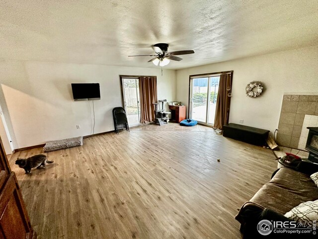 506 E 1st Ave, Otis, CO 80743 - living room with light wood-style floors, a textured ceiling, a ceiling fan, and baseboards