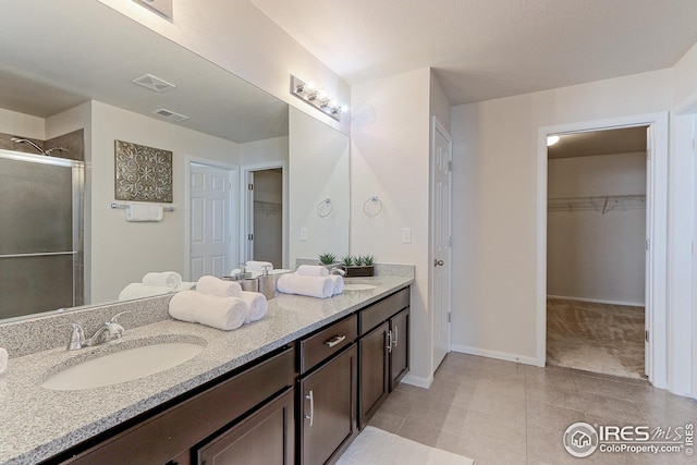 full bathroom featuring a shower stall, vanity, tile patterned flooring, and visible vents
