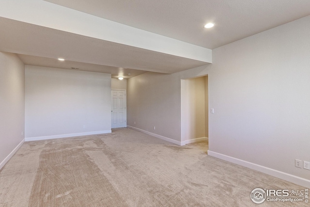 spare room featuring recessed lighting, baseboards, and light colored carpet