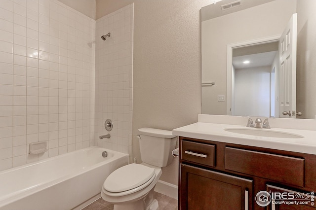 bathroom featuring visible vents, toilet, vanity, tub / shower combination, and baseboards