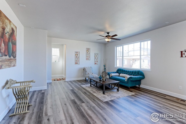 living room with wood finished floors, visible vents, and a wealth of natural light
