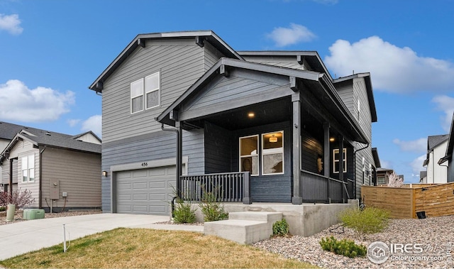 craftsman-style house featuring concrete driveway, fence, a garage, and covered porch