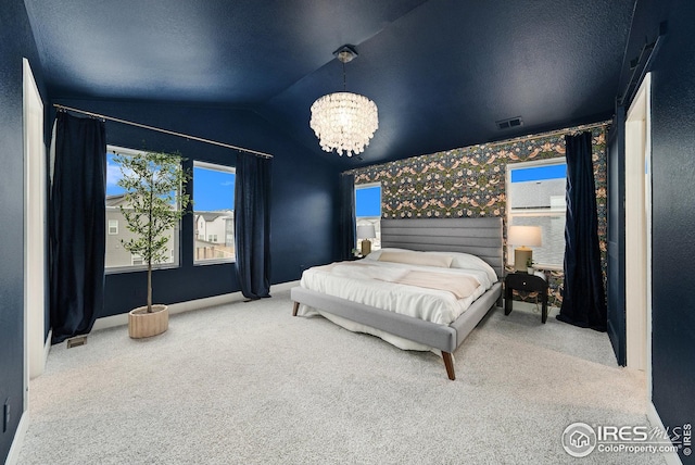 carpeted bedroom with wallpapered walls, vaulted ceiling, visible vents, and a chandelier