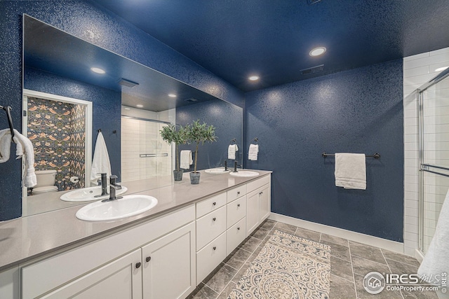 bathroom featuring a sink, double vanity, and a stall shower