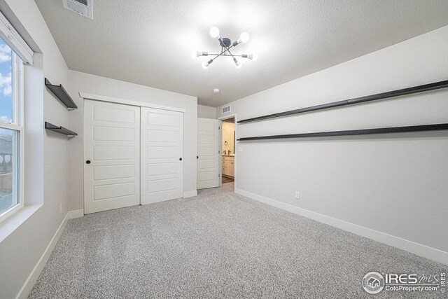 unfurnished bedroom featuring baseboards, multiple windows, visible vents, and carpet