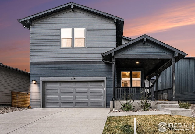 traditional home featuring driveway, a porch, and a garage