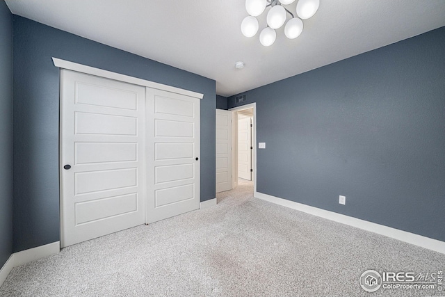 unfurnished bedroom featuring visible vents, baseboards, carpet, and a closet