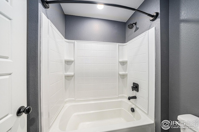bathroom with a textured wall and toilet