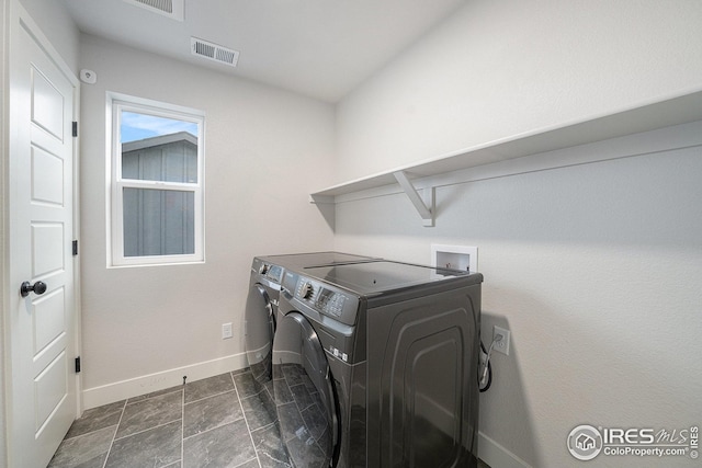 laundry area with baseboards, visible vents, washer and clothes dryer, and laundry area